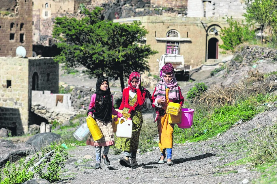 KEMARAU PANJANG: Kanak-kanak perempuan berjalan sambil membawa bekas untuk mengambil air dari paip di Bani Matar, Yaman, pada 24 Ogos 2023. Yaman antara negara paling sukar mendapat bekalan air di dunia, disebabkan kemarau akibat perubahan iklim.
