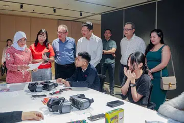 LAWATAN PRESIDEN: Puan Halimah Yacob (paling kiri) berinteraksi dengan belia yang menerima khidmat kesihatan mental TOUCH dan turut menyaksikan mereka mencuba kegiatan realiti maya (VR) yang membantu mereka belajar mengawal emosi.