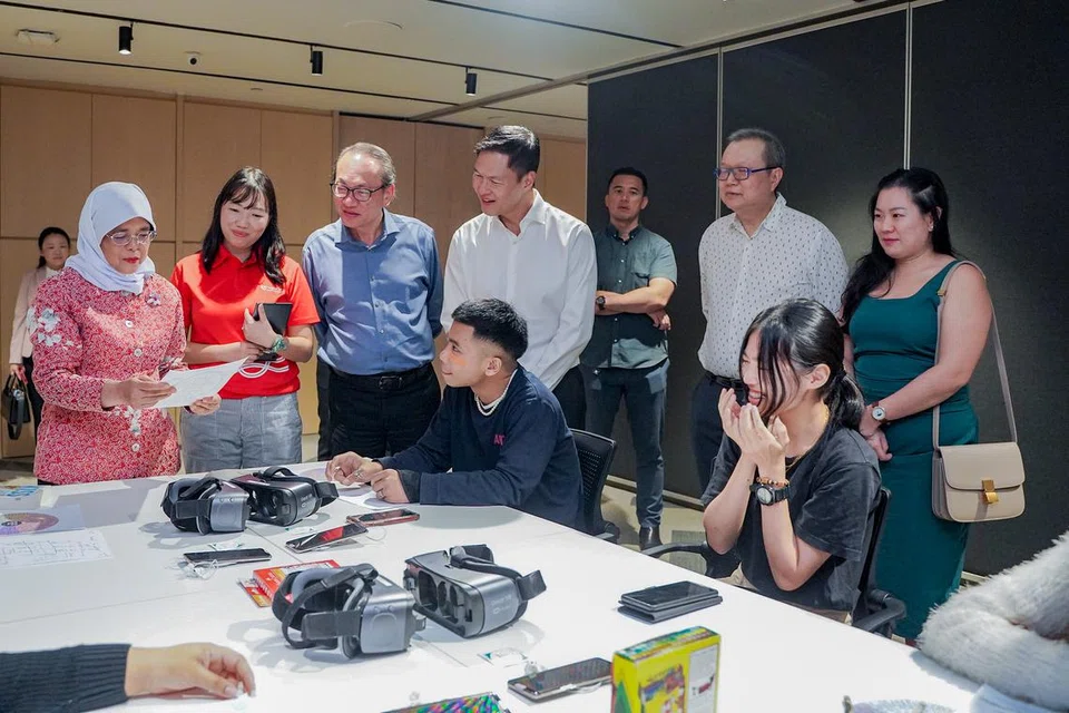 LAWATAN PRESIDEN: Puan Halimah Yacob (paling kiri) berinteraksi dengan belia yang menerima khidmat kesihatan mental TOUCH dan turut menyaksikan mereka mencuba kegiatan realiti maya (VR) yang membantu mereka belajar mengawal emosi.