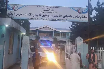 SIAP SAMBUT MANGSA: Pejuang Taliban dan kakitangan perubatan berdiri di luar pintu pagar hospital menunggu ketibaan mangsa letupan di daerah Imam Sahib di Kunduz. - Foto AFP