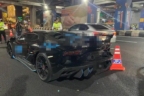 Anggota polis menjalankan pemeriksaan terhadap kereta mewah Lamborghini yang ditahan dalam Operasi Khas Hari Raya Aidilfitri di Jalan Bangsar, Kuala Lumpur, pada malam 8 April.