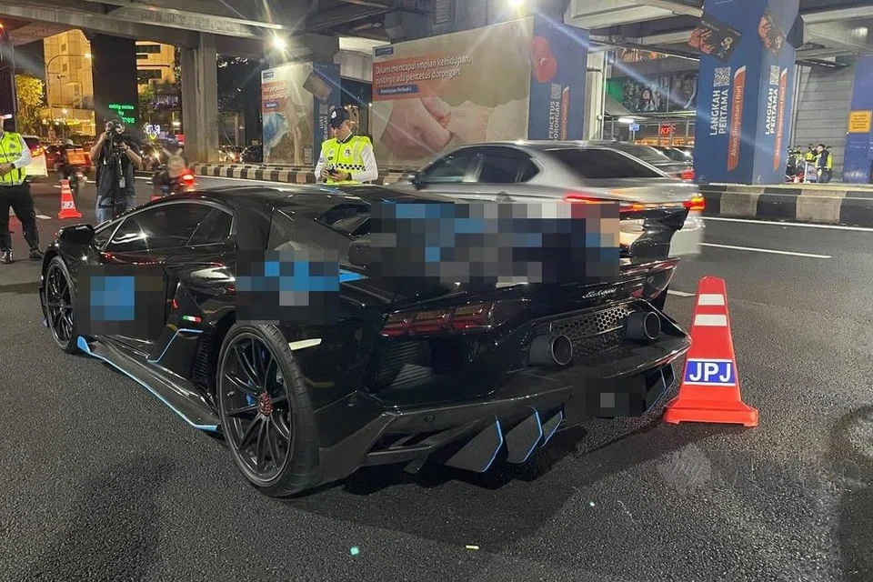 Anggota polis menjalankan pemeriksaan terhadap kereta mewah Lamborghini yang ditahan dalam Operasi Khas Hari Raya Aidilfitri di Jalan Bangsar, Kuala Lumpur, pada malam 8 April.