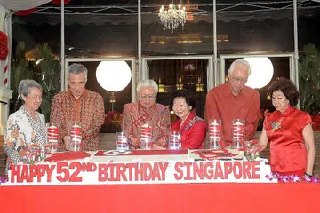 RAIKAN HARI KEBANGSAAN: (Dari kiri) Cik Ho Ching, Encik Lee Hsien Loong, Dr Tony Tan, Cik Mary Tan, Encik Goh Chok Tong dan Cik Tan Choo Leng memotong kek ulang tahun Singapura yang ke-52 secara bersama-sama di majlis jamuan malam di Istana malam tadi. - Foto JOHARI RAHMAT