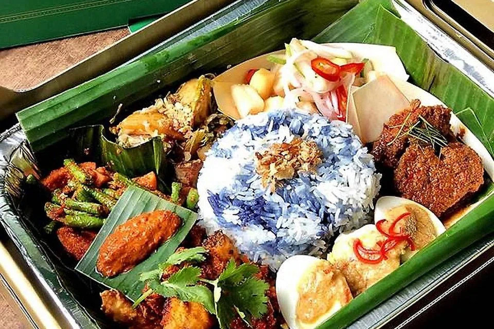 LAHIR KEPRIHATINAN: Anggota masyarakat Melayu dan Jawa Singapura meluahkan keprihatinan dengan penamaan dulang makanan Violet Oon Singapore sebagai 'Nyonya Nasi Ambeng Trays' (kiri) yang dianggap sebagai 'cultural appropriation' atau pengambilan kebudayaan luar. - Foto FACEBOOK VIOLET OON SINGAPORE