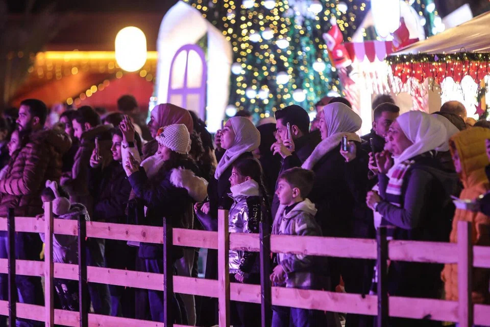 Rakyat Syria bergambar di sebuah pasar Krismas di Damsyik menjelang sambutan perayaan Krismas pada 22 Disember 2025. Pada awal Disember, Presiden Syria menggesa rakyat negara itu bersatu dan bekerjasama membina semula Syria sempena genap setahun penyingkiran pemerintah lama Bashar al-Assad. 