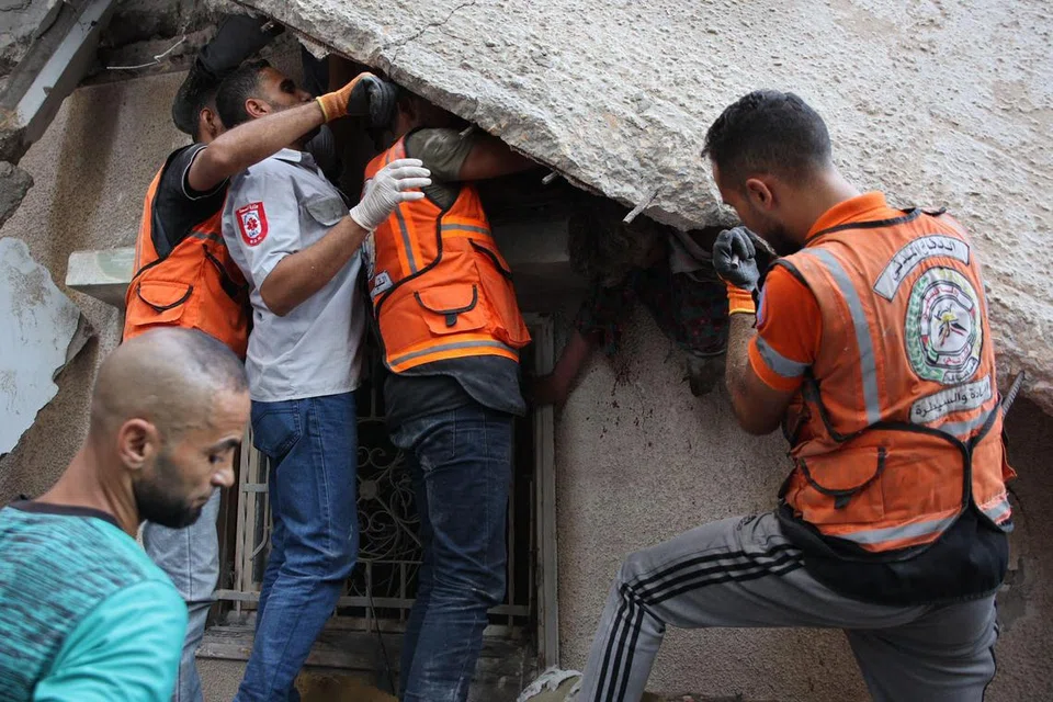 Pasukan perubatan Palestin menggali runtuhan bangunan ketika mencari mangsa yang terselamat selepas serangan Israel ke atas sebuah bangunan di kejiranan al-Daraj di Bandar Gaza pada 17 September.