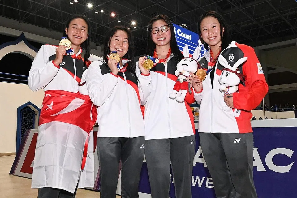PECAH REKOD: Pasukan berganti-ganti campuran 4x100 meter wanita - yang terdiri daripada (dari kanan) Faith Khoo, Letitia Sim, Quah Jing Wen dan Quah Ting Wen - menang emas untuk Singapura dan sekali gus memecah rekod Sukan SEA dengan catatan masa 4:06.97 pada Khamis. - Foto-foto ST