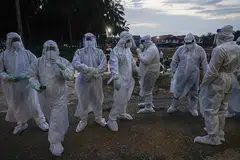BUKAN LANGKAH MENYERAMKAN, TAPI KESELAMATAN: Pekerja kesihatan yang ditugaskan menguruskan pengebumian mangsa Covid-19 mengenakan pakaian hazmat serba putih sewaktu urusan pengebumian di Kuala Selangor Isnin lalu. - Foto EPA-EFE