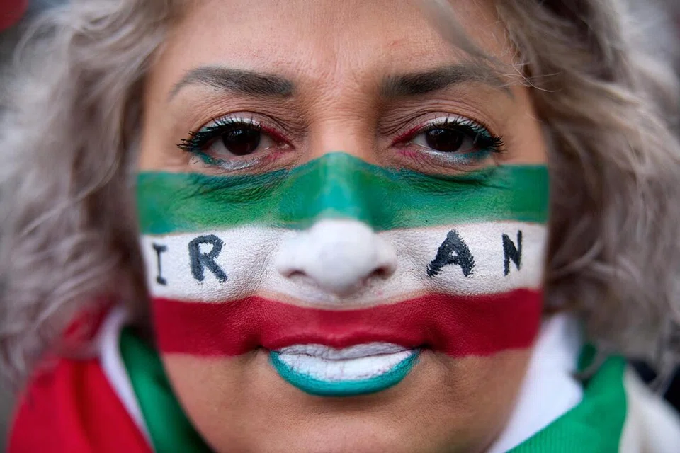 Seorang penunjuk perasaan mengecat wajahnya dengan warna bendera Iran dan perkataan ‘Iran’ semasa demonstrasi bagi menyokong perhimpunan besar-besaran yang mengecam Republik Islam di Iran, di Paris pada 11 Januari 2026. 