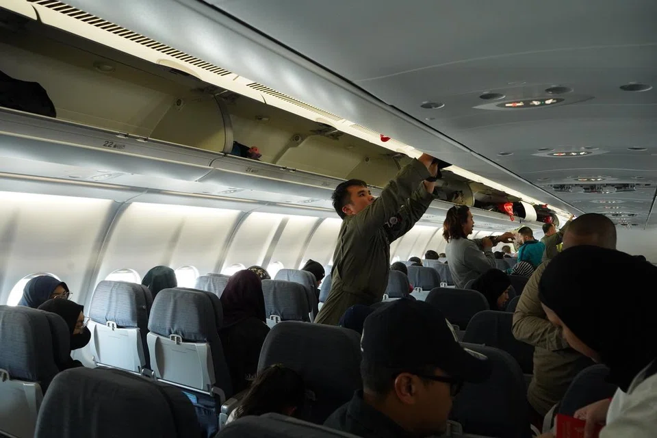 Askar SAF membantu penumpang dalam pesawat RSAF dari Jeddah ke Singapura.