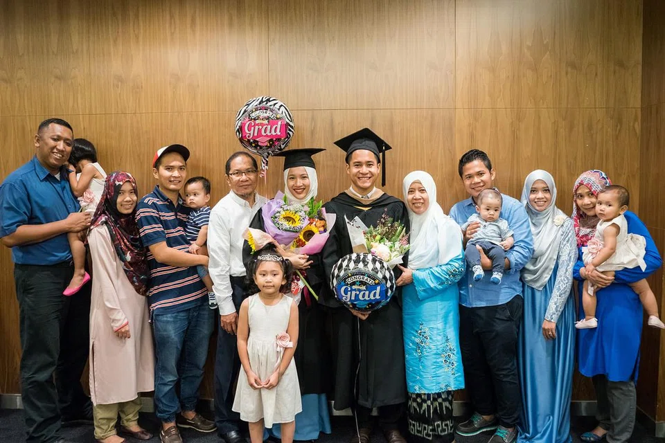 ADIK DAN RAKAN SEKELAS: Encik Abdul Latif (lima dari kanan) bersama adiknya Siti Mardhiyyah (turut memakai pakaian siswazah) diapit anggota keluarga selepas menerima ijazah masing-masing.- Foto NUR ASHIQAH LAU