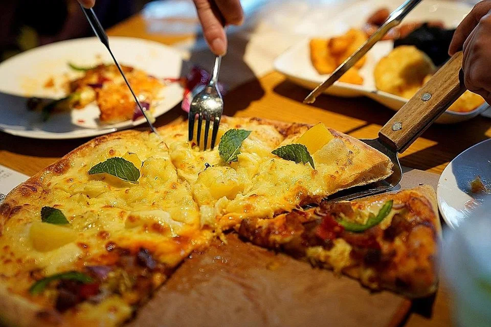 TARIKAN DURIAN: Hidangan piza durian menarik pelanggan ke restoran La Cesar Pizzaria di Shanghai, China, sementara sajian sup ayam durian panas memikat pelanggan ke Coconut Chicken Hotpot Store, juga di Shanghai. - Foto REUTERS