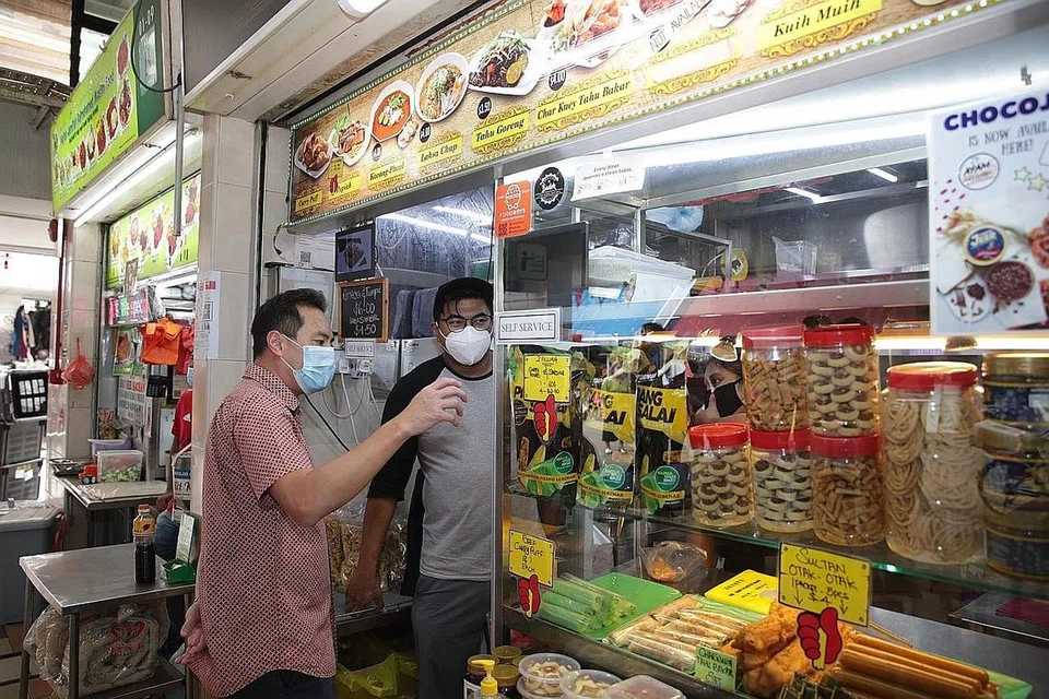 KUNJUNGI GERAI: Encik Tan Kiat How (kiri) mengunjungi sebuah gerai di Pasar dan Pusat Makanan Haig Road untuk mendapatkan maklum balas dan bagaimana mereka bertahan sewaktu pandemik ini. - Foto BH oleh TIMOTHY DAVID