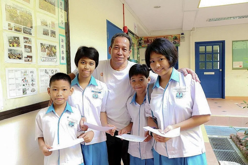 MAHU CUCU BELAJAR LEBIH RAJIN: Encik Jaafar (tengah) bersama empat cucunya yang diasuh seperti anaknya sendiri, (dari kiri), Mohamed Rusyaidi Mirza, Rasyiqah Darwisyah, Ulfah Nur Syauqinah dan Farah Wasimah, yang menerima dermasiswa daripada CCC Geylang Serai semalam. - Foto PUTRI MARDHIYAH YAZID