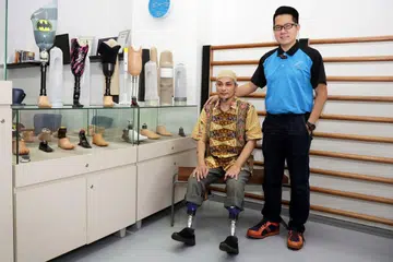 CUBA BERDIKARI: Encik Mohamad Hasri (kiri) berusaha memasarkan produk prostetik syarikat milik Encik Desmond Lim (kanan) yang turut membuka cawangannya di Johor Bahru.- Foto BH oleh GIN TAY