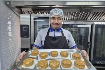 Encik Norizam Noordin, pekerja di Minds Bakers, seronok membakar kuih bulan.