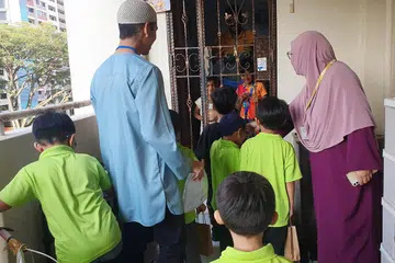 Pelajar tadika Madrasah Perdaus mendekati jiran tetangga berbilang agama dan bangsa dengan mengagihkan pek Ramadan, dan ditemani oleh asatizah daripada Perdaus.