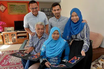 KEJAYAAN TIGA DALAM SATU: Encik Mohd Zakee Chemat (duduk, kiri) dan Cik Latifah Ahmad (duduk, kanan) dilambung kegembiraan berganda kerana ketiga-tiga anak mereka - (dari kiri) Encik Muhammad Hafiz, Encik Muhammad Hairul Izwan dan Cik Siti Nur Amira - berjaya merangkul ijazah sarjana muda daripada Universiti Teknologi Nanyang (NTU) serentak tahun ini. - Foto TUKIMAN WARJI