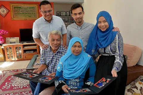 KEJAYAAN TIGA DALAM SATU: Encik Mohd Zakee Chemat (duduk, kiri) dan Cik Latifah Ahmad (duduk, kanan) dilambung kegembiraan berganda kerana ketiga-tiga anak mereka - (dari kiri) Encik Muhammad Hafiz, Encik Muhammad Hairul Izwan dan Cik Siti Nur Amira - berjaya merangkul ijazah sarjana muda daripada Universiti Teknologi Nanyang (NTU) serentak tahun ini. - Foto TUKIMAN WARJI