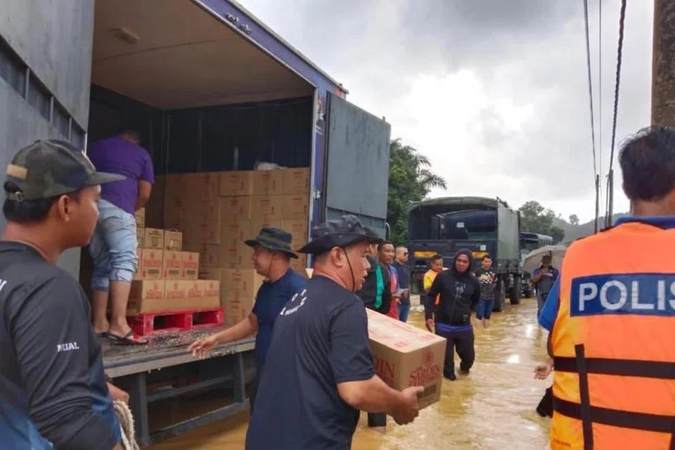 RINGANKAN BEBAN: Pelbagai pihak termasuk pihak berkuasa, anggota penyelamat dan pertubuhan bukan kerajaan (NGO) berganding bahu mengangkut barangan bantuan untuk diagihkan kepada mangsa banjir di pusat pemindahan sementara (PPS) di Kuantan, Pahang.