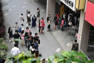 TUNGGU GILIRAN: Ramai orang dilihat beratur di luar Chinatown Point semalam petang, menunggu giliran untuk memasuki semula pusat beli-belah itu selepas api dipadamkan. - Foto BH oleh CHONG JUN LIANG