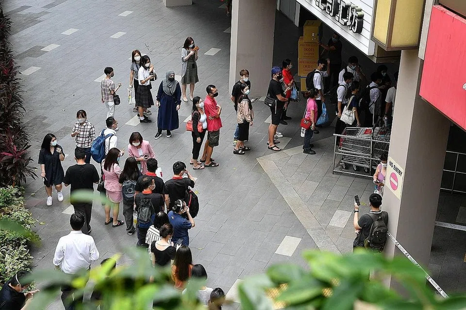 TUNGGU GILIRAN: Ramai orang dilihat beratur di luar Chinatown Point semalam petang, menunggu giliran untuk memasuki semula pusat beli-belah itu selepas api dipadamkan. - Foto BH oleh CHONG JUN LIANG