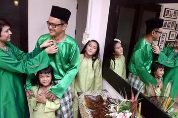 REZEKI BARU DI AIDILFITRI: Sambil sibuk membuat persiapan bagi Hari Raya, Encik Ridzal, yang bersama isteri, Cik Norliza Hussin, dan dua anak mereka, Nadia Farhana (kanan) dan Nurul Iman, tidak sabar mahu kembali menyumbang kepada sukan ragbi melalui tugasnya sebagai pengurus khidmat ragbi bagi Asia bersama Lembaga Ragbi Antarabangsa (IRB). - Foto TAUFIK A. KADER