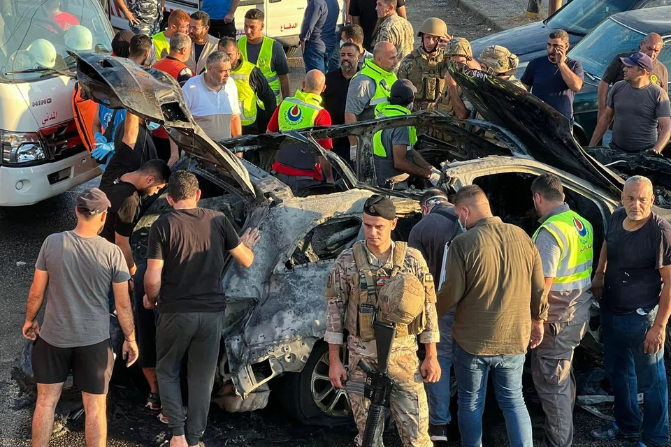 Pasukan keselamatan Lebanon memeriksa sebuah kereta yang terbakar akibat serangan Israel di selatan Sidon, Lebanon.