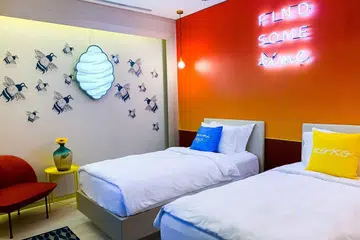 PERLUAS RUANG: Ruang di Hotel Naumi ini kelihatan lebih luas apabila empat pelajar Politeknik Temasek ini mengetepikan meja belajar, menanggalkan langsir dan menghias tembok hotel dengan motif lebah dan cogan kata bercahaya. - Foto HOTEL NAUMI SINGAPORE 