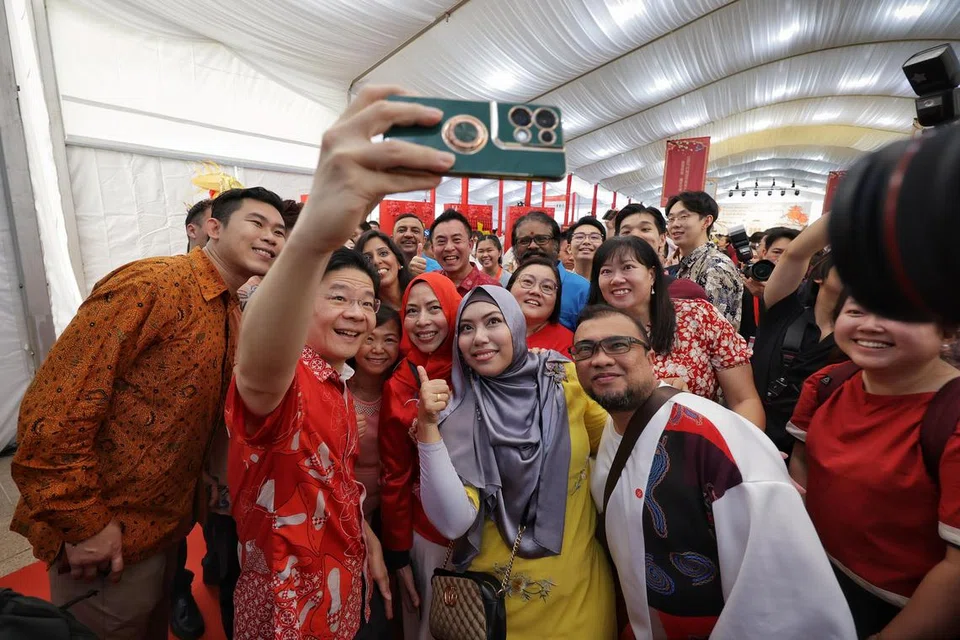 Encik Lawrence Wong   mengambil swafoto bersama tetamu semasa satu majlis Tahun Baru Cina di halaman Istana pada 25 Februari. 