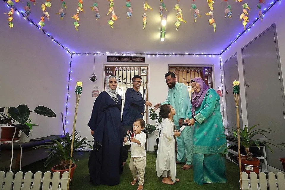 MERIAH RAYA: Koridor di hadapan dua unit flat ini digabung dan dihias jiran tetangga (dari kiri) Cik Juliana, suaminya Encik Sabri, Encik Azan dan isteri Cik Zulaifa. Mereka digambar bersama anak-anak Encik Sabri dan Cik Juliana, Luth Aldriq (kiri) dan Ifra Nur Dayana. - Foto BH oleh GAVIN FOO