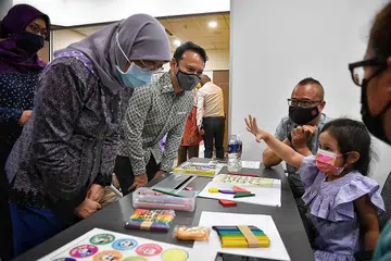 TINJAU PROGRAM: Presiden Halimah Yacob (kiri) dan Encik Zaqy Mohamad (dua dari kiri) meninjau program KelasMateMatika, kelas pengayaan yang mengajar konsep asas pengiraan. - Foto fail