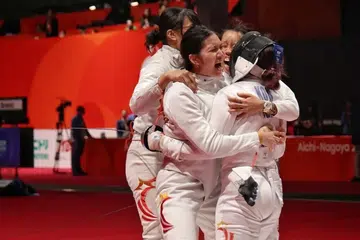 Elle Koh (kanan) dari Singapura diserbu rakan sepasukan selepas memastikan kemenangan 42-41 ke atas Uzbekistan dalam suku akhir acara lawan pedang epee berpasukan wanita di Sukan Asia, 25 September.
