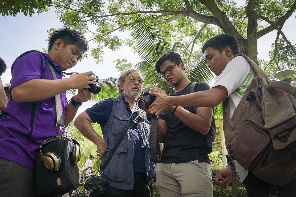 PANDANGAN PROFESIONAL: Pelajar ITE ini termasuk Encik Shahrin Aidil (dua dari kanan) sedang mendapatkan pandangan profesional daripada jurugambar 'National Geographic', Encik Michael Yamashita (dua dari kiri) mengenai gambar yang mereka petik. 