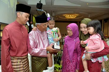 BAWEAN TELADAN: Encik Hawazi (dua dari kiri, mendukung cucu Nur Zahra Sofia) meraikan penerimaan Anugerah Bawean Teladan tahun ini bersama keluarga (dari kiri) anak Encik Muhammad Taufiq, isteri Cik Essah Hussain, menantu Cik Nur Hazwani Abu Samah dan cucu Nur Daaniyah Iman. - Foto M.O. SALLEH