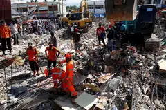 MENCARI MANGSA TERPERANGKAP: Anggota penyelamat dengan menggunakan jentera berat giat mengalihkan timbunan runtuhan untuk mencari mangsa yang terperangkap di pasar Meureudu, Pidie Jaya, Aceh, semalam. - Foto REUTERS