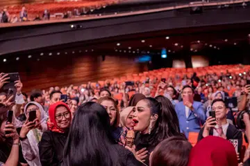 DEKATI PEMINAT: Kris Dayanti dengan ramah turun dari pentas untuk mendekati peminat setianya sambil mendendangkan lagu kegemaran mereka.