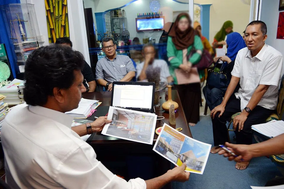 DESAK PULANGKAN WANG PELABURAN PROJEK MARINA VIEW RESORT & SPA: Para pelabur yang rungsing dan kecewa mendengar dengan tekun nasihat Sheikh Nawaz (memegang gambar), pemilik firma timbang tara Bilal Consultants, mengenai tindakan yang boleh mereka lakukan ke atas pemaju projek terbengkalai dalam pertemuan mereka baru-baru ini. - Foto JOHARI RAHMAT