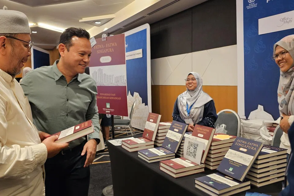 Menteri Negara Kanan (Pertahanan merangkap Tenaga Manusia), Encik Zaqy Mohamad (dua dari kiri), bersama Timbalan Mufti Singapura, Ustaz Dr Mohammad Hannan Hassan (kiri), semasa melawat reruai di acara Perkampungan Legasi Wakaf Masyarakat Singapura pada 30 Ogos di Suntec Singapore.