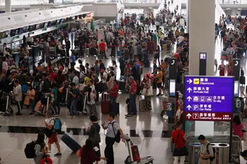 OPERASI DISAMBUNG SEMULA: Pengembara beratur untuk check-in di Lapangan Terbang Hong Kong setelah ia dibuka semula setelah penerbangan dibatalkan akibat bantahan di lapangan terbang itu semalam. -Foto REUTERS. 