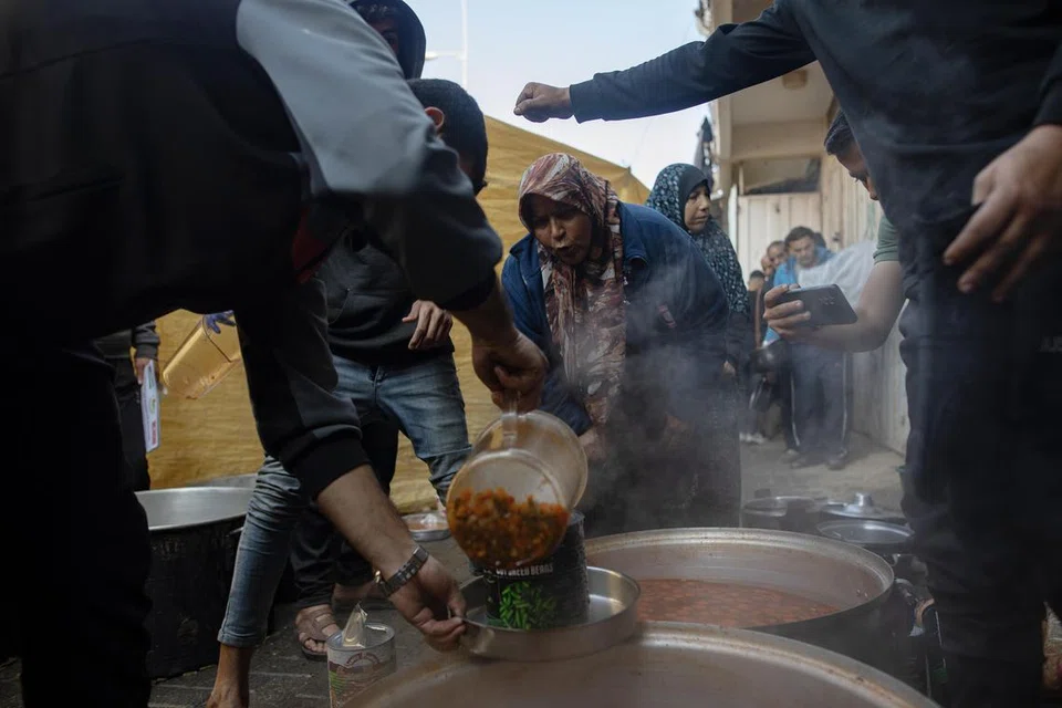 TERUS DICENGKAM KESUSAHAN: Penduduk Palestin beratur bagi mendapatkan makanan percuma yang disediakan relawan di Khan Younis, selatan Gaza. 
