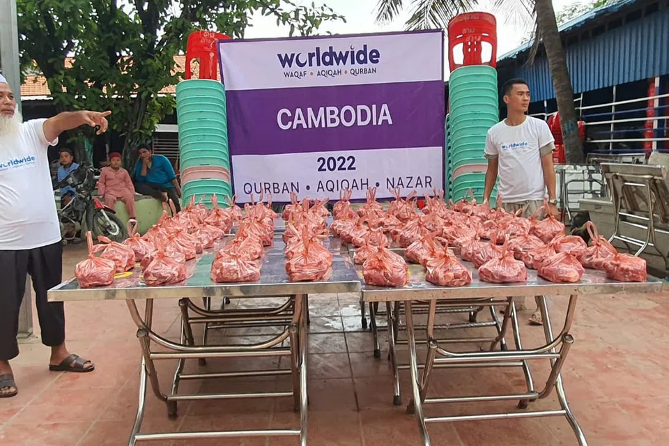 SALING MEMBANTU: Warga setempat bekerjasama dengan syarikat BNiaga (Worldwide) di Kemboja dengan membantu mengagihkan daging korban kepada golongan memerlukan.