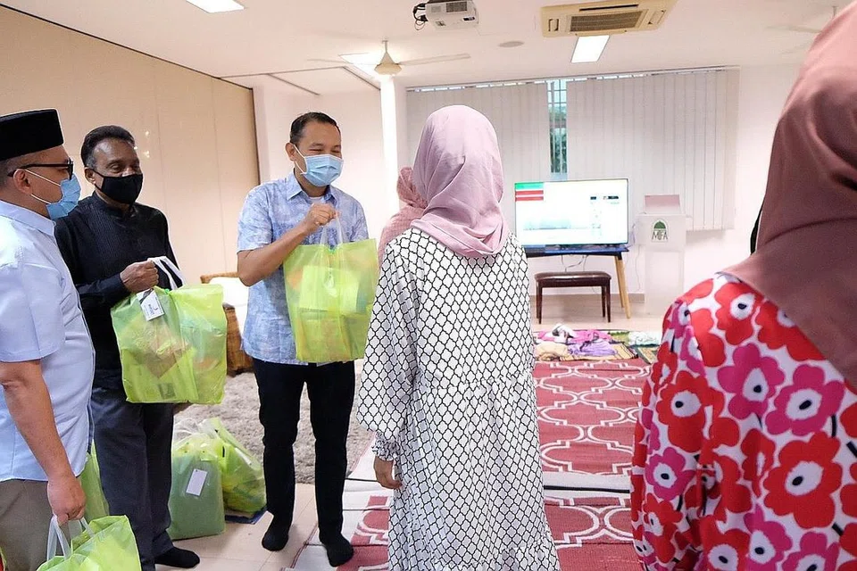 BERI HABUAN: Encik Fahmi Aliman (tiga dari kiri) menghulurkan beg habuan kepada anak-anak yatim Darul Ihsan sebelum berbuka puasa dengan mereka kelmarin. Bersama beliau ialah (dari kiri), Timbalan Pengurus Besar BigFoot Logistics, Encik Farid Aliman, dan CEO Kumpulan/Pengarah, bagi Kumpulan Syarikat BigFoot, Encik Sanny Abdullah, yang merupakan antara penaja acara tersebut. - Foto BM oleh KHALID BABA