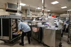 SEDIAKAN MAKANAN: (Atas) Kakitangan menyediakan makanan dan memuatkannya ke dalam troli di dapur bawah tanah Hospital Besar Singapura (SGH). Ia mengambil masa sekitar dua jam untuk menghantar makanan kepada semua pesakit pada waktu makan, yang bermula pada 6.15 pagi untuk sarapan, 10.15 pagi untuk makan tengah hari dan 4.15 petang untuk makan malam.