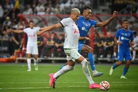 TIDAK ‘GOYANG’ DICABAR: Penyerang Tottenham Hotspur kelahiran Brazil,  Richarlison, menepis pemain pertahanan Lion City Sailors, Bill Mamadou, sebelum menjaringkan gol ketiga sekali gus mencipta hatrik pertamanya untuk Spurs dalam perlawanan pramusim Piala Tiger di Stadium Negara pada Rabu.