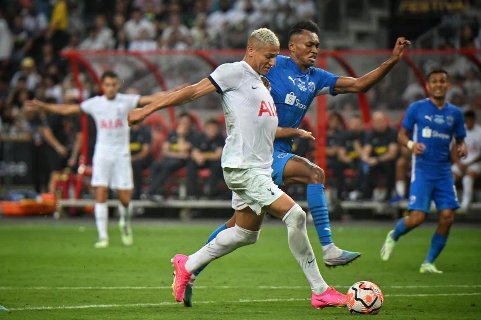 TIDAK ‘GOYANG’ DICABAR: Penyerang Tottenham Hotspur kelahiran Brazil,  Richarlison, menepis pemain pertahanan Lion City Sailors, Bill Mamadou, sebelum menjaringkan gol ketiga sekali gus mencipta hatrik pertamanya untuk Spurs dalam perlawanan pramusim Piala Tiger di Stadium Negara pada Rabu.