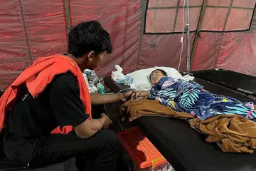 JAGA ADIK: Encik Salman Alfarisi, menemani adiknya, Azka, yang terselamat meskipun berada di bawah timbunan runtuhan selama dua hari selepas berlaku gempa bumi. - Foto REUTERS
