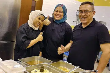 JALANKAN AMANAH: Pemilik bersama dan ketua cef Fleur Cafe, Encik Ashaari Taha, bersama kakitangannya sedang menyiapkan juadah buka puasa untuk dihantar kepada pelanggan. - Foto FLEUR CAFE