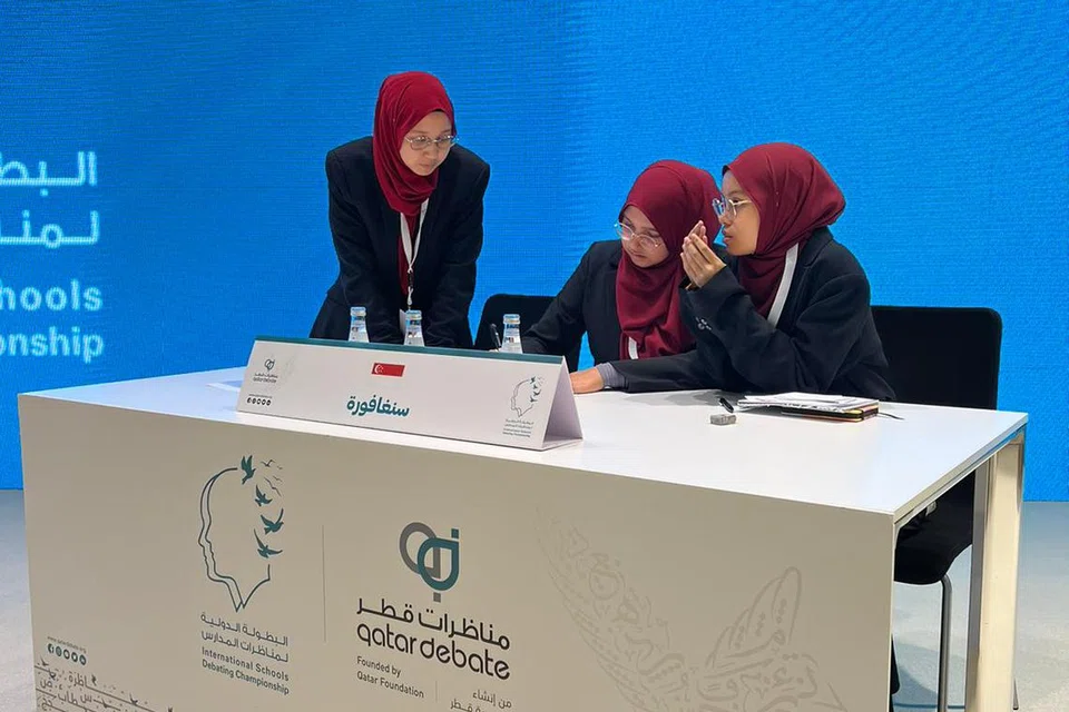 PUSINGAN AKHIR: Pasukan Singapura kelihatan membuat persiapan dalam salah satu pusingan akhir pertandingan pidato di Qatar.