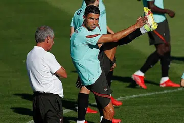 DEDIKASI: (Atas) Cristiano Ronaldo berlatih dengan rakan pasukannya dari Portugal bersama jurulatih Fernando Santos bagi Kelayakan Piala Dunia - Foto AFP, REUTERS